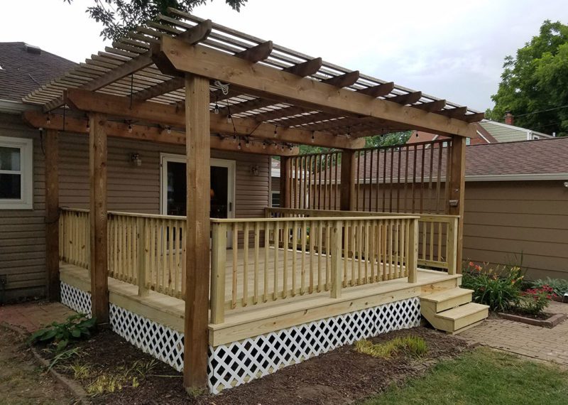 A wooden deck with a pergola attached to it.