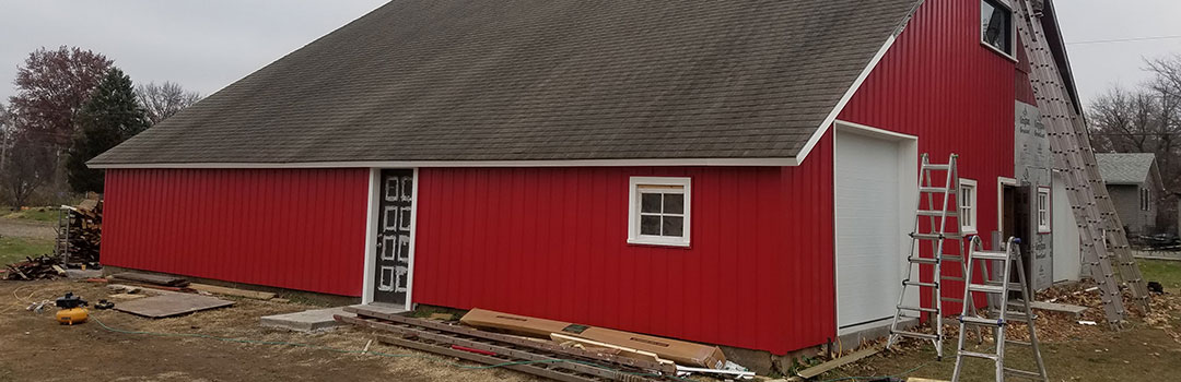 A barn with stacks of wood outside