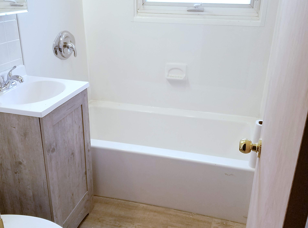 An empty bathtub next to a sink