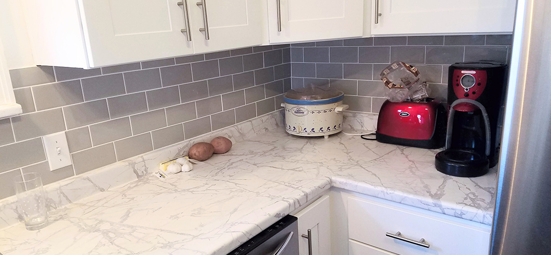 A kitchen with white cabinets and granite countertops.