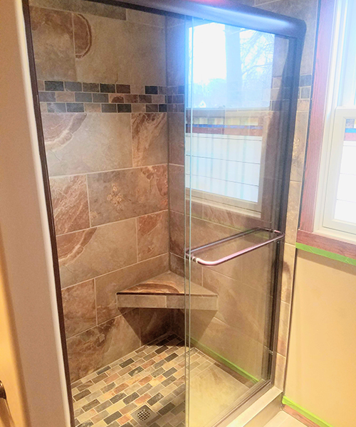 A shower area with open glass doors