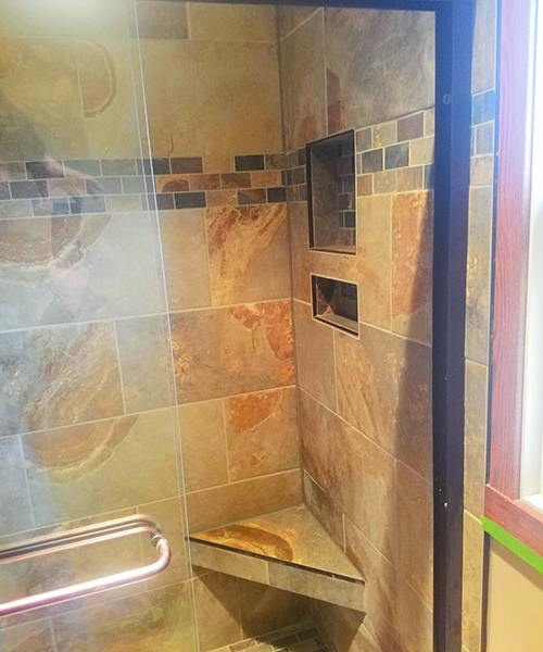 A shower area with shelves and glass doors