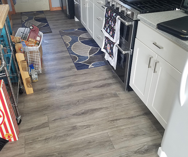 A kitchen with clean floors and closed cabinets