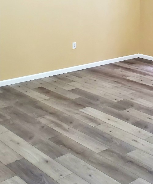 A room with wood floors and a yellow wall.