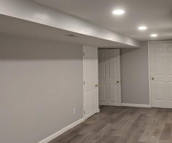 A room with white walls and wood floors.