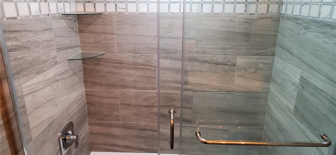 A bathroom with a shower and tiled walls.