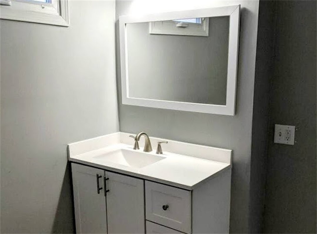 A bathroom with a sink and mirror in it