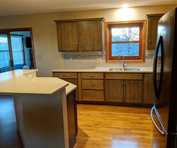 A kitchen with a sink and a fridge