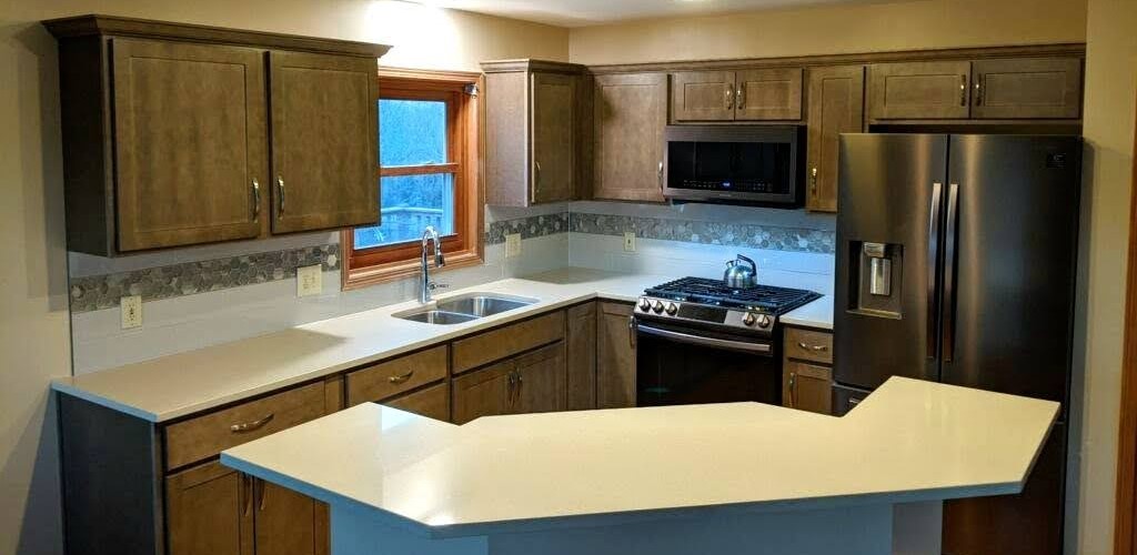 A kitchen with brown cabinets and white counters.