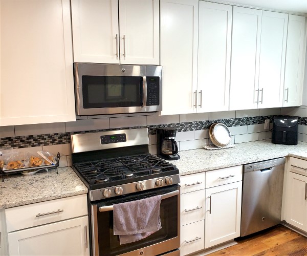 A kitchen with white cabinets and stainless steel appliances.