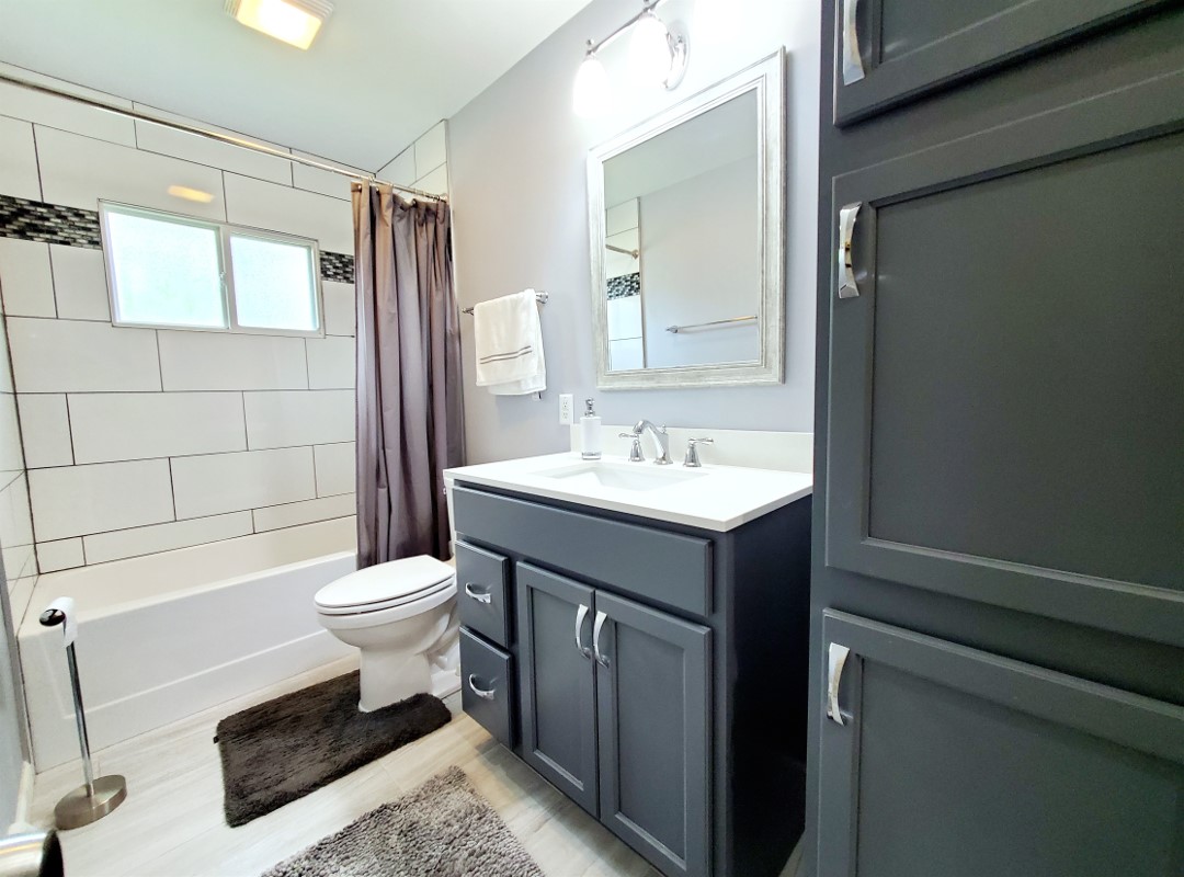 A bathtub with tiled walls