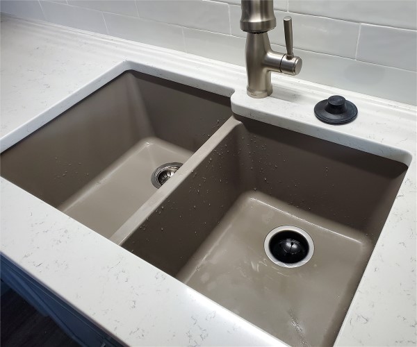 A sink with two sinks and one faucet.