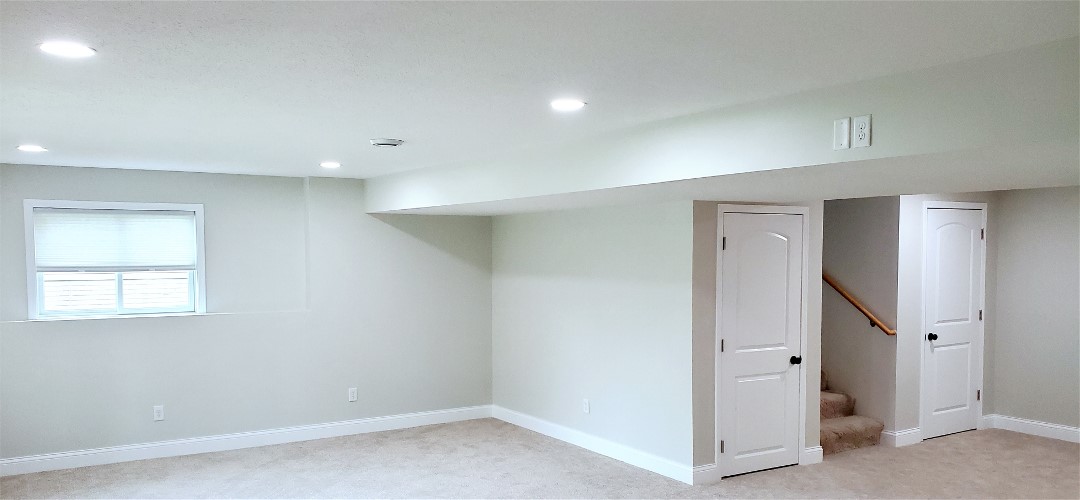 A room with white walls and beige carpet.