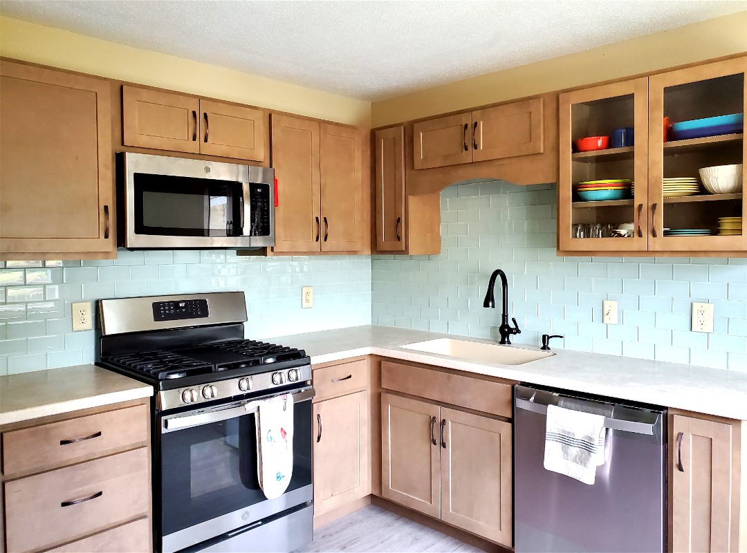 A kitchen with appliances and wooden furniture