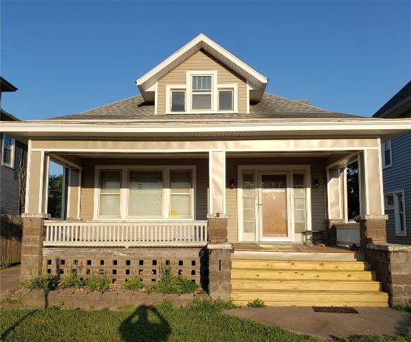 A house with steps leading to the front door.