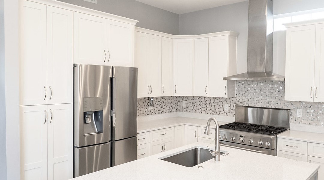 A kitchen with white cabinets and stainless steel appliances.