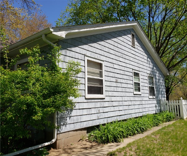 A house with a garden and bushes in front of it.