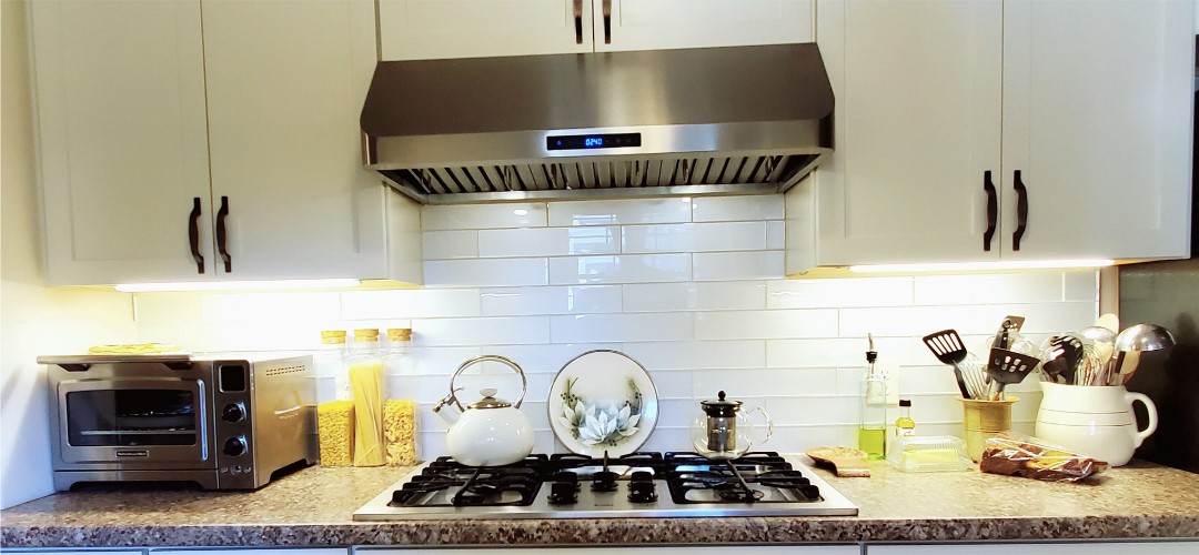 A kitchen with a stove and a kettle on it