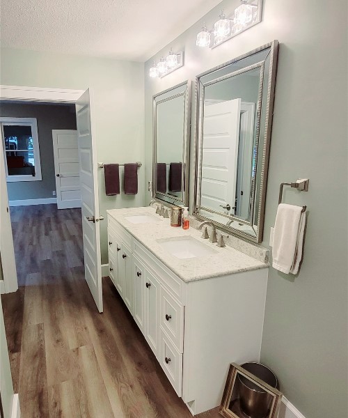 A bathroom with two sinks and mirrors in it