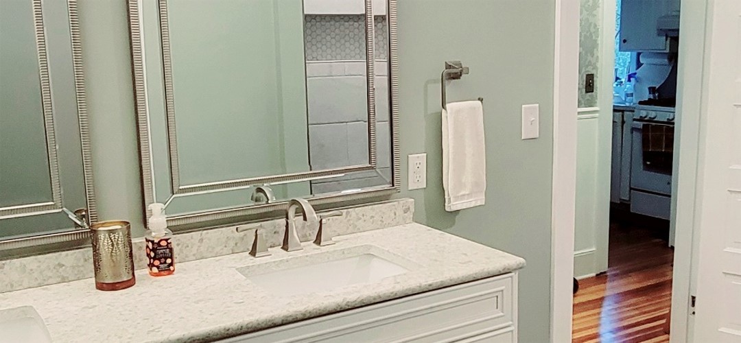 A bathroom with two sinks and a mirror.