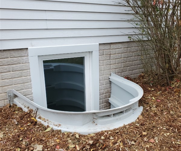 A small window in the side of a house.