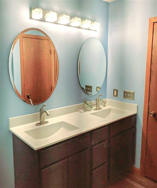 A bathroom with two sinks and mirrors in it