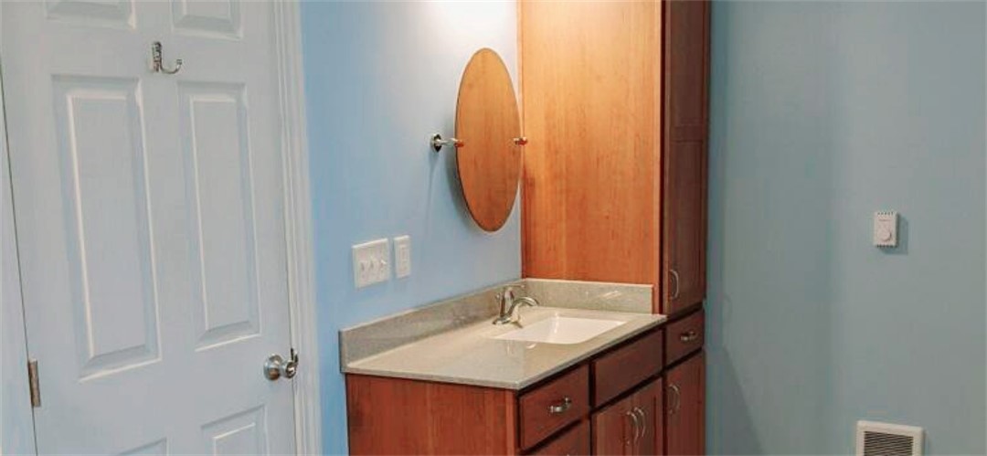 A bathroom with a sink and mirror in it