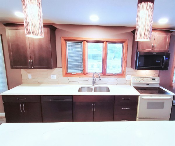 A kitchen with brown cabinets and white counters