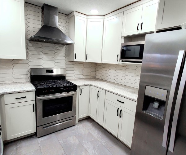 A kitchen with white cabinets and stainless steel appliances.