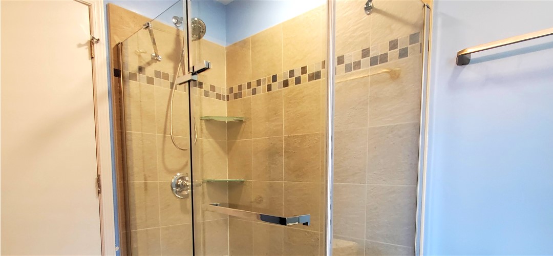 A bathroom with a shower and tiled walls.