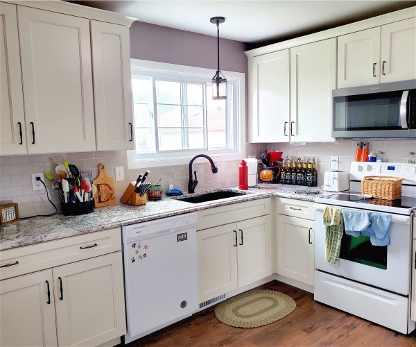 A kitchen with white cabinets and appliances in it