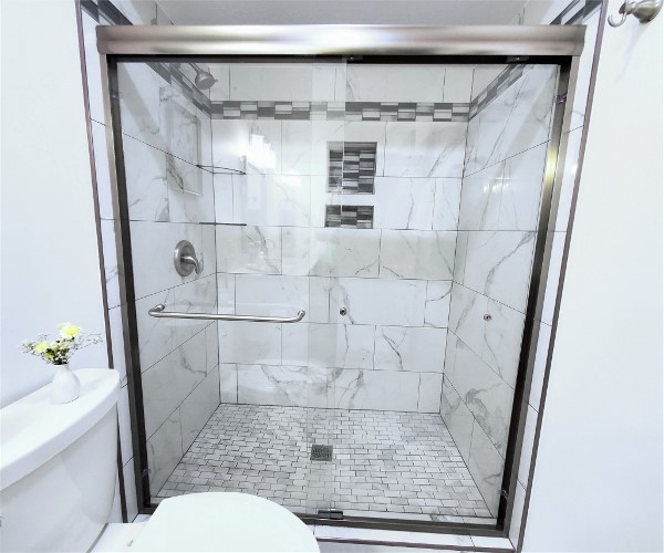 A shower area with glass panels