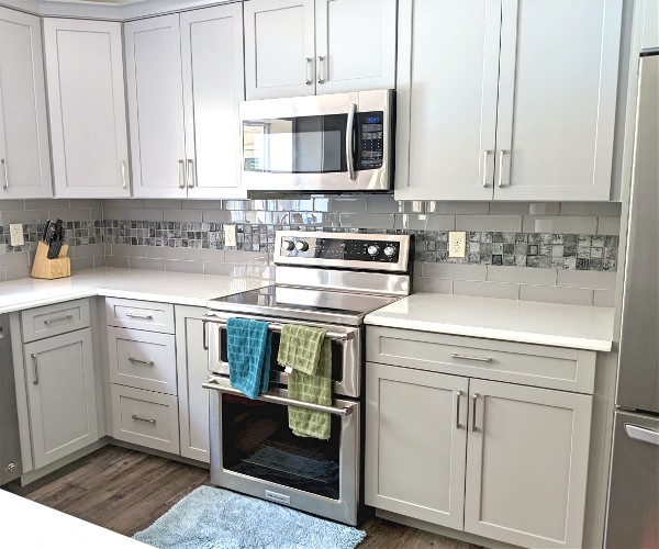 A kitchen with white cabinets and stainless steel appliances.