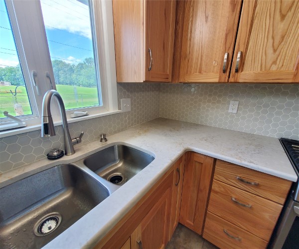 A kitchen with wooden cabinets and white counter tops.