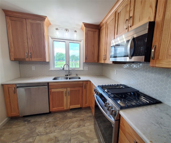 A kitchen with wooden cabinets and stainless steel appliances.