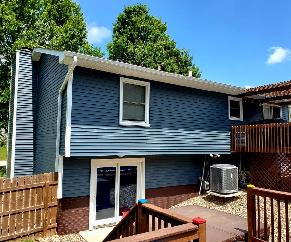 A blue house with an air conditioner and deck