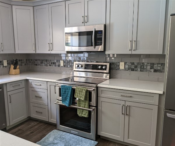 A kitchen with white cabinets and stainless steel appliances.