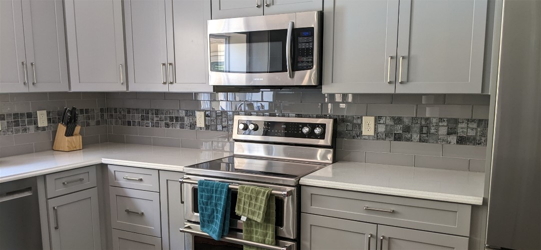 A kitchen with white cabinets and stainless steel appliances.