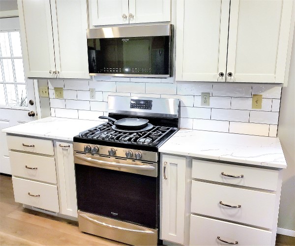 A kitchen with a clean stove and a microwave