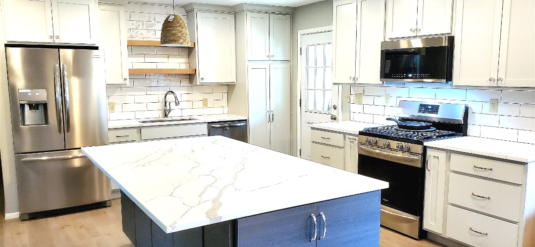 A kitchen with white cabinets and blue island