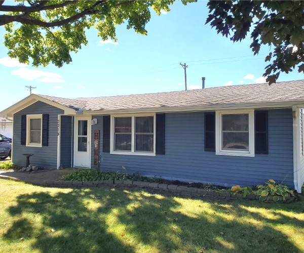 A blue house with white trim and black shutters.