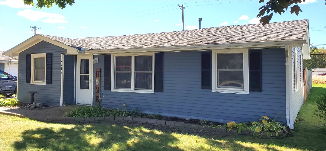 A blue house with black shutters and white trim.