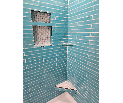 A blue tiled shower with two windows and a corner shelf.