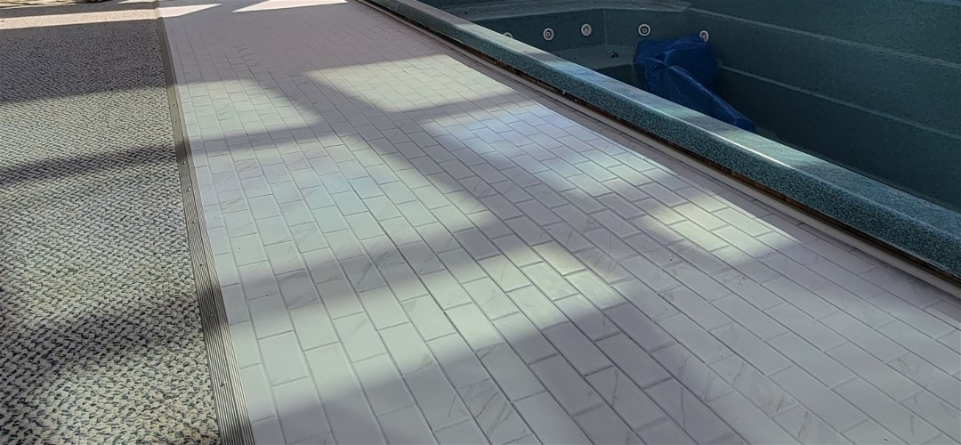 A tile floor with a pool in the middle of it