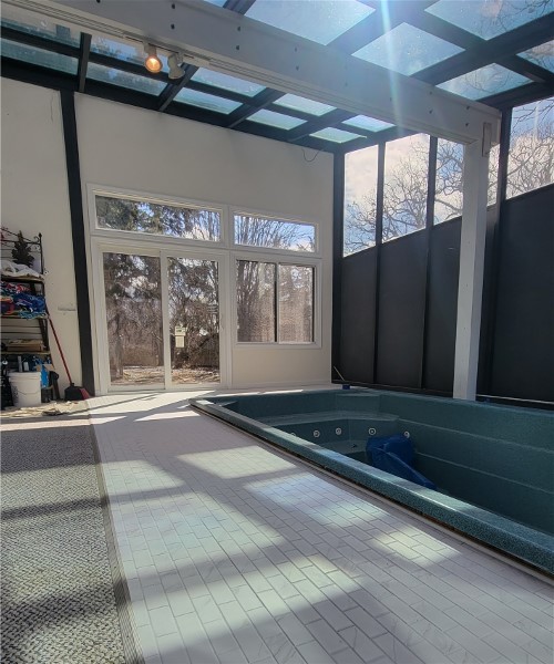 A large indoor pool with a view of the outside.