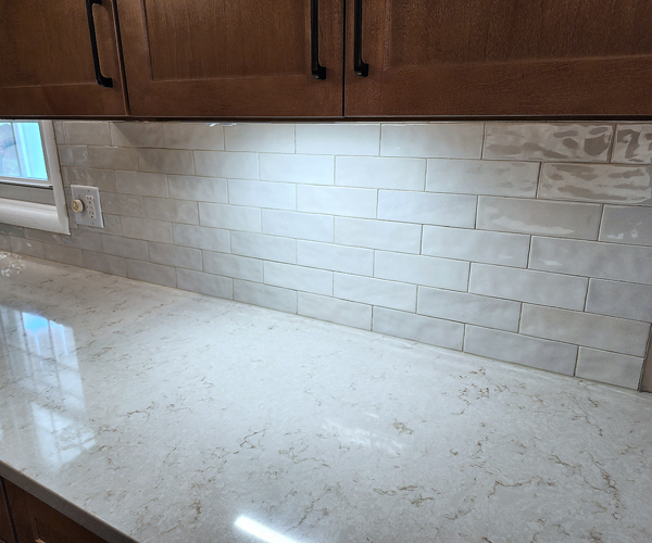 A kitchen with a white counter top and wooden cabinets.