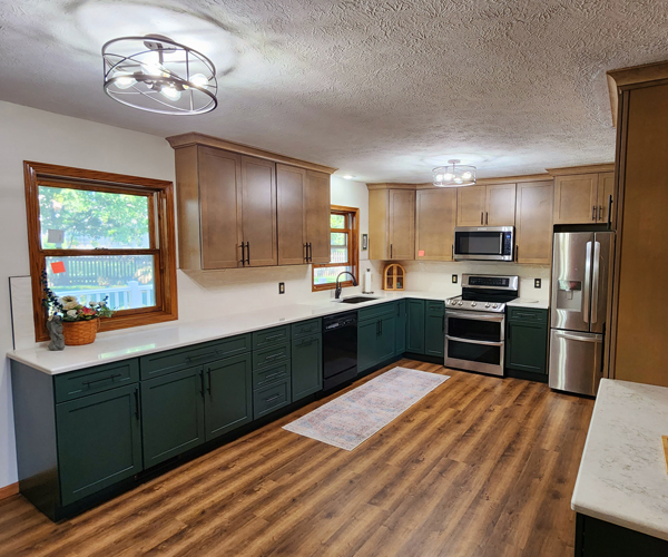 A kitchen with green cabinets and hardwood floors.