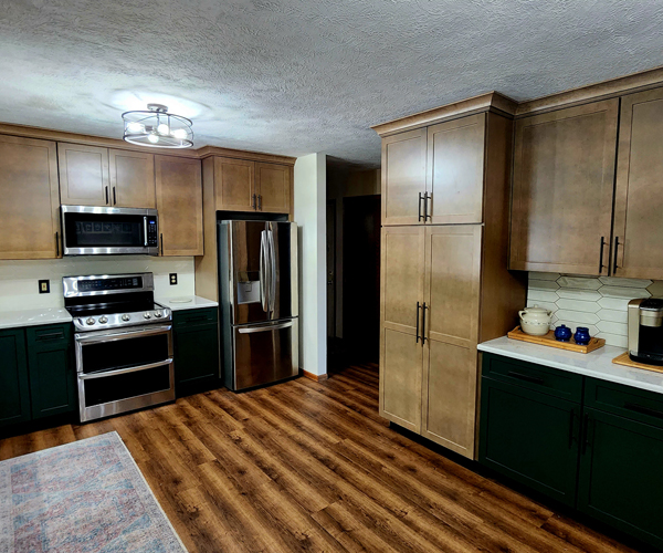 A kitchen with green cabinets and stainless steel appliances.