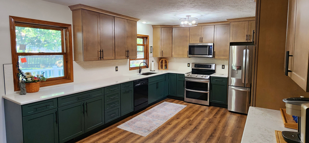 A kitchen with green cabinets and stainless steel appliances.